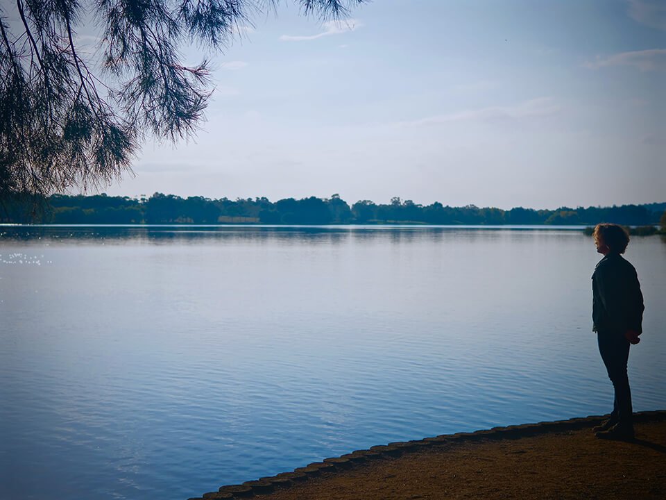 Woman looking pensively into the lake