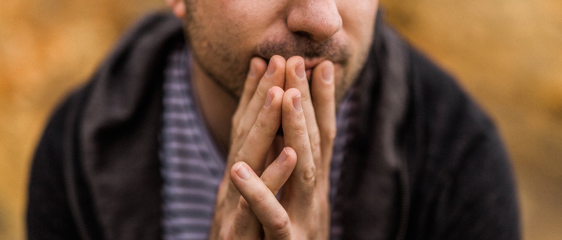 a close up of a person holding their hands together.