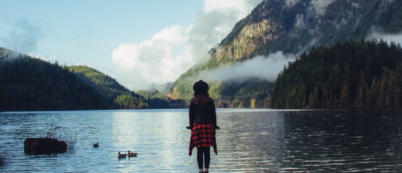 a woman standing on the edge of a lake.