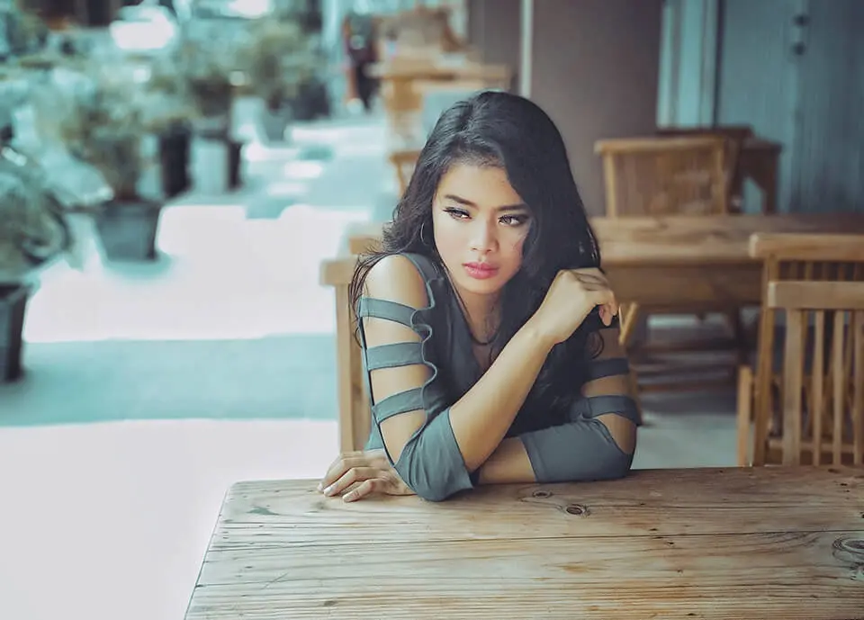 Woman looking upset while sitting at an outdoor dining table