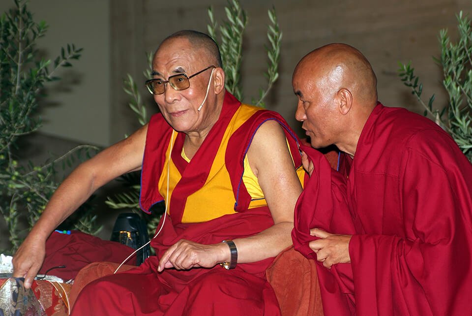 The Dalai Lama speaking with a monk