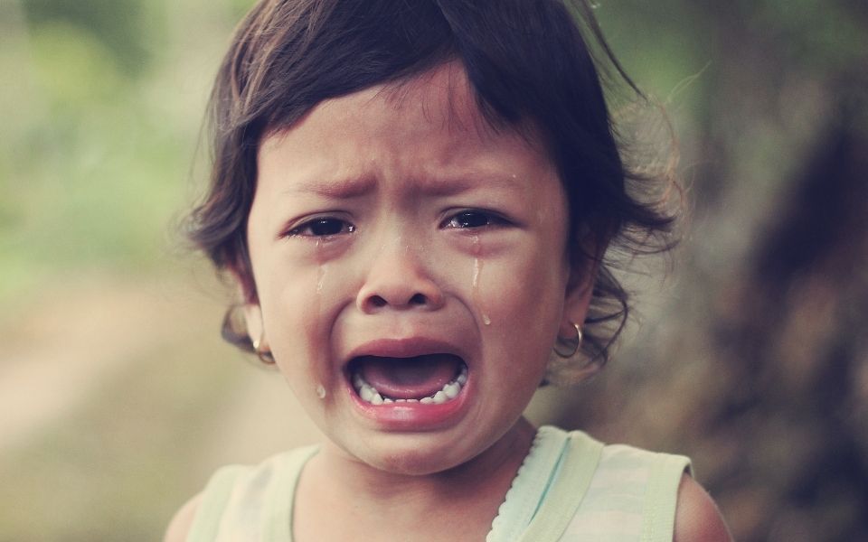 Little girl looking into camera crying