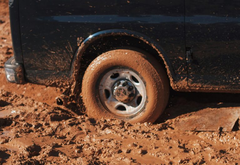 a close up of a truck tire on a dirt road.