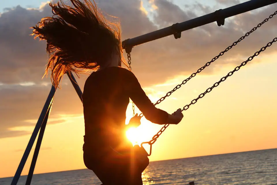 Woman happily swinging on a swingset