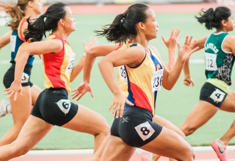 a group of women running on a track.