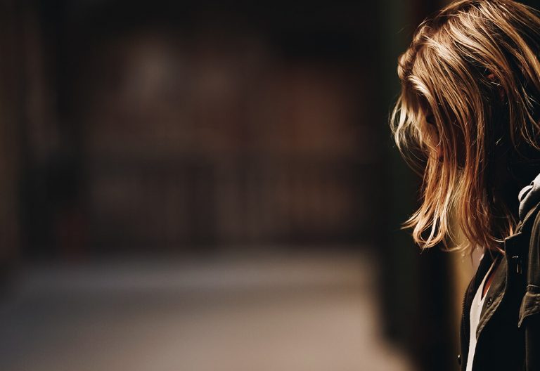 a woman standing in a hallway with her back to the camera.