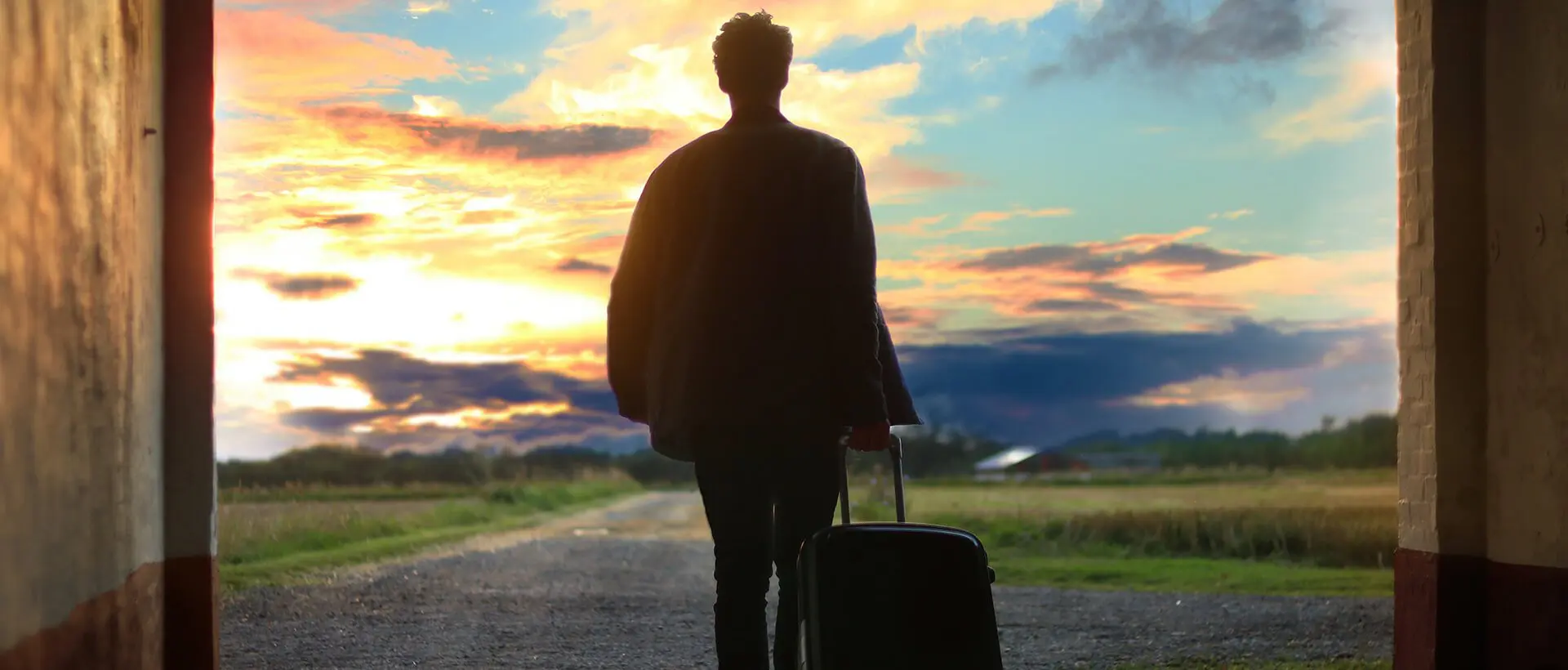 a man with a suitcase is walking out of a tunnel.