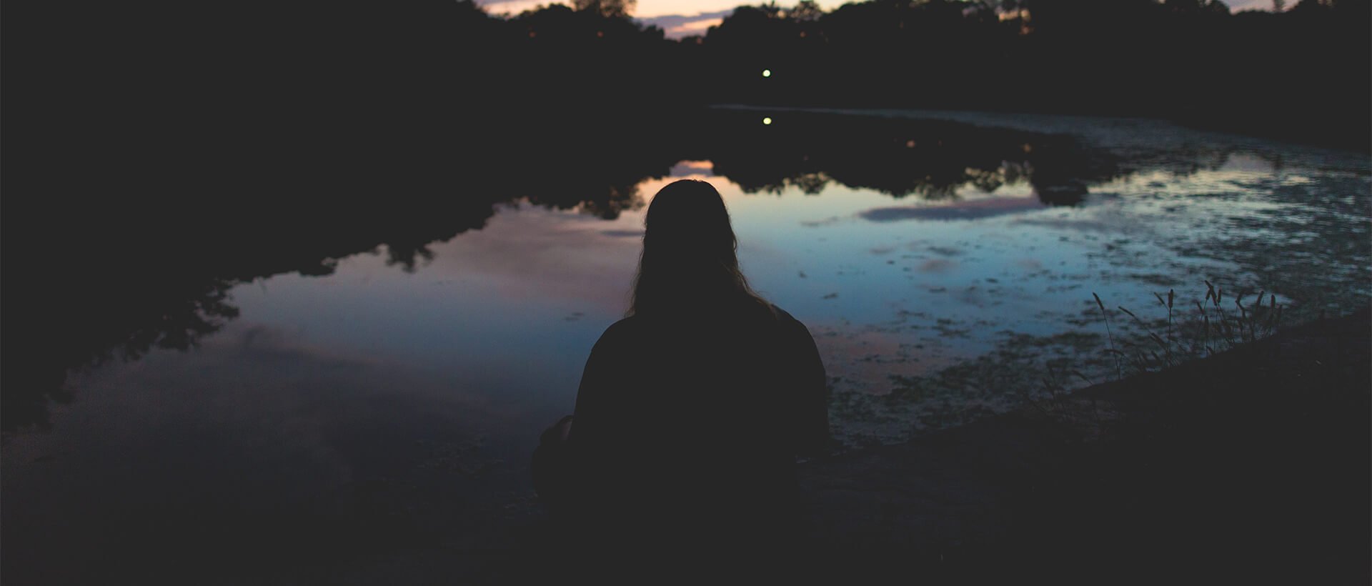 a person standing in front of a body of water.