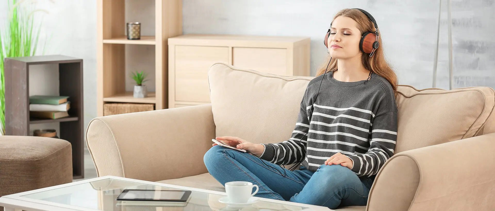 a woman sitting on a couch listening to music.