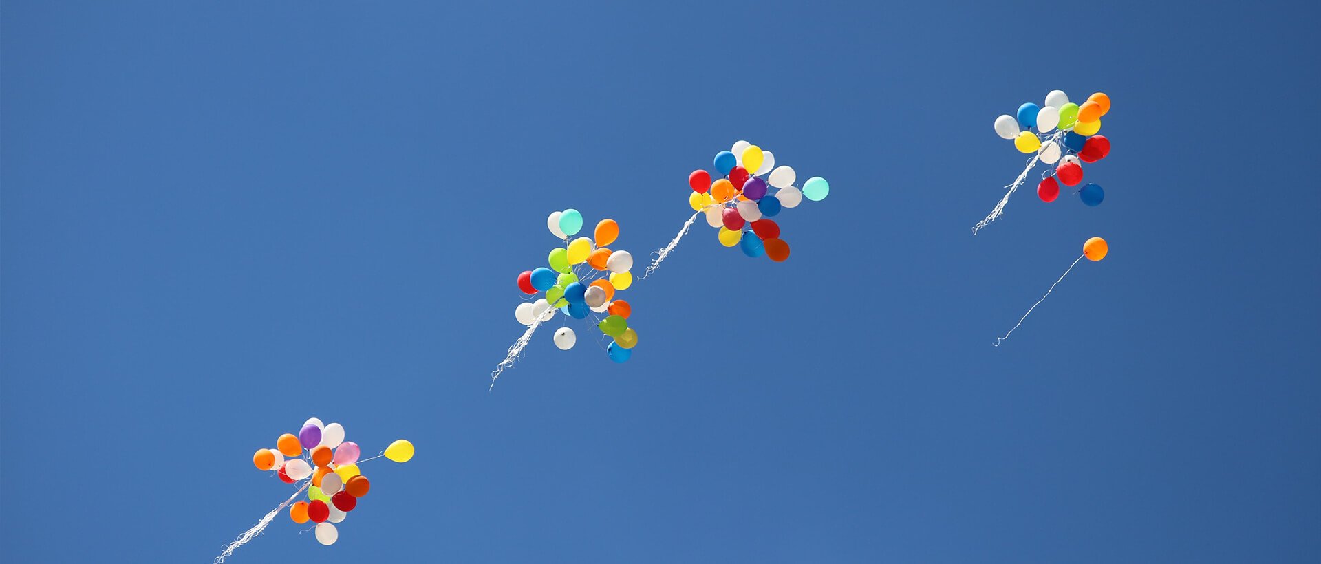 a group of balloons flying in the sky.