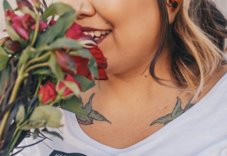 a woman holding a bouquet of flowers in front of her face.