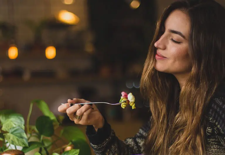 a woman holding a spoon with a flower in it.