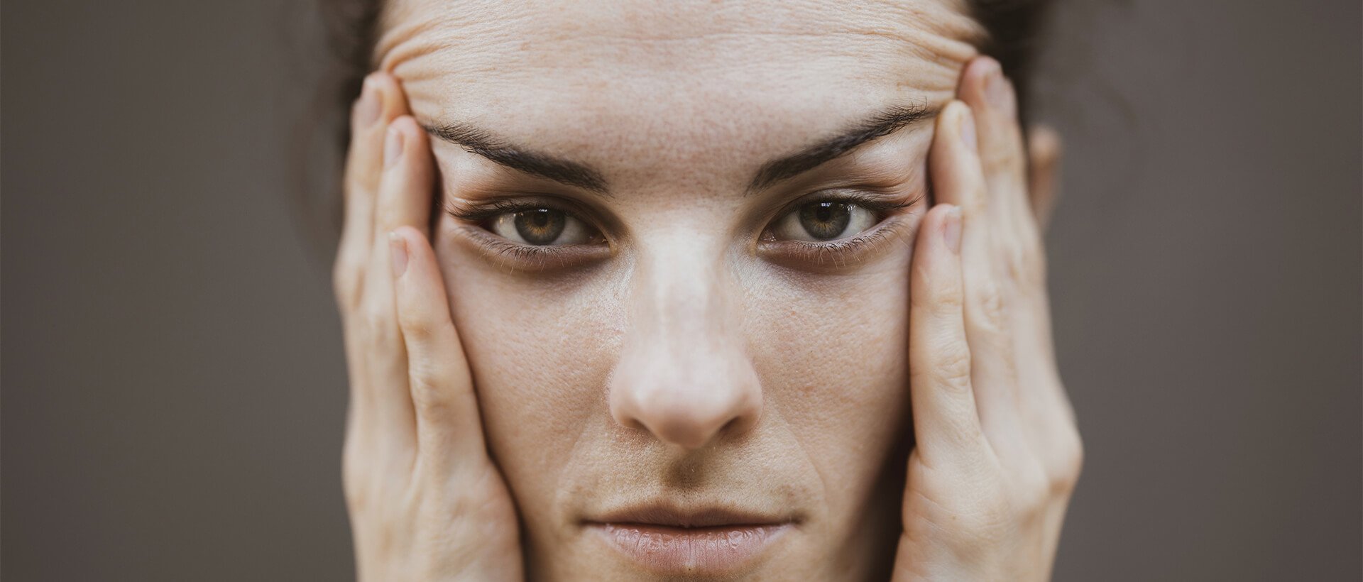 a woman holding her hands to her face.