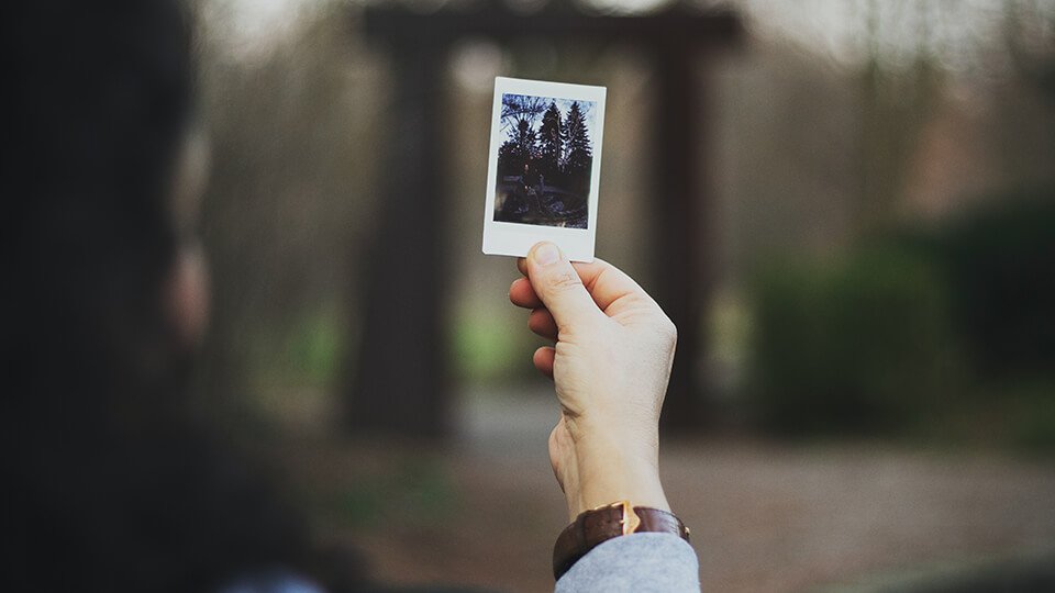 Woman holding up polaroid 