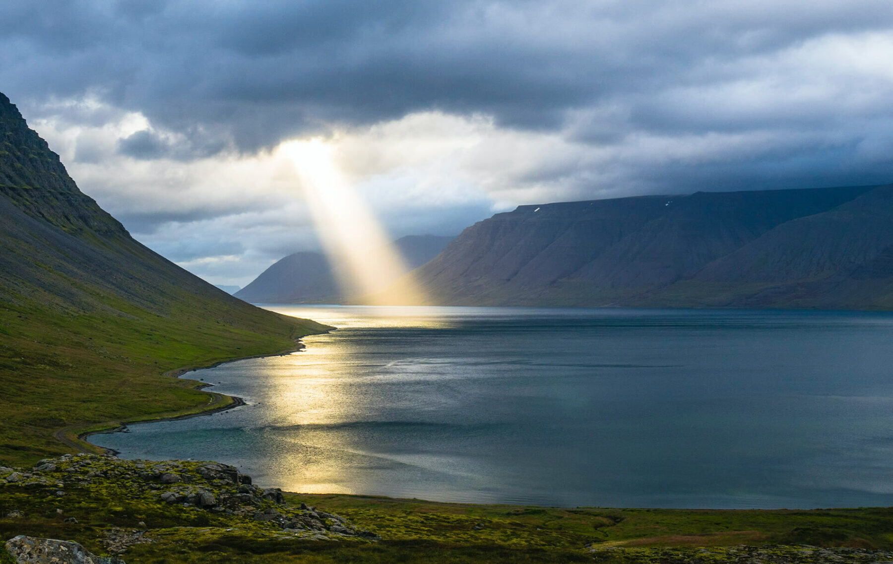 a large body of water surrounded by mountains.