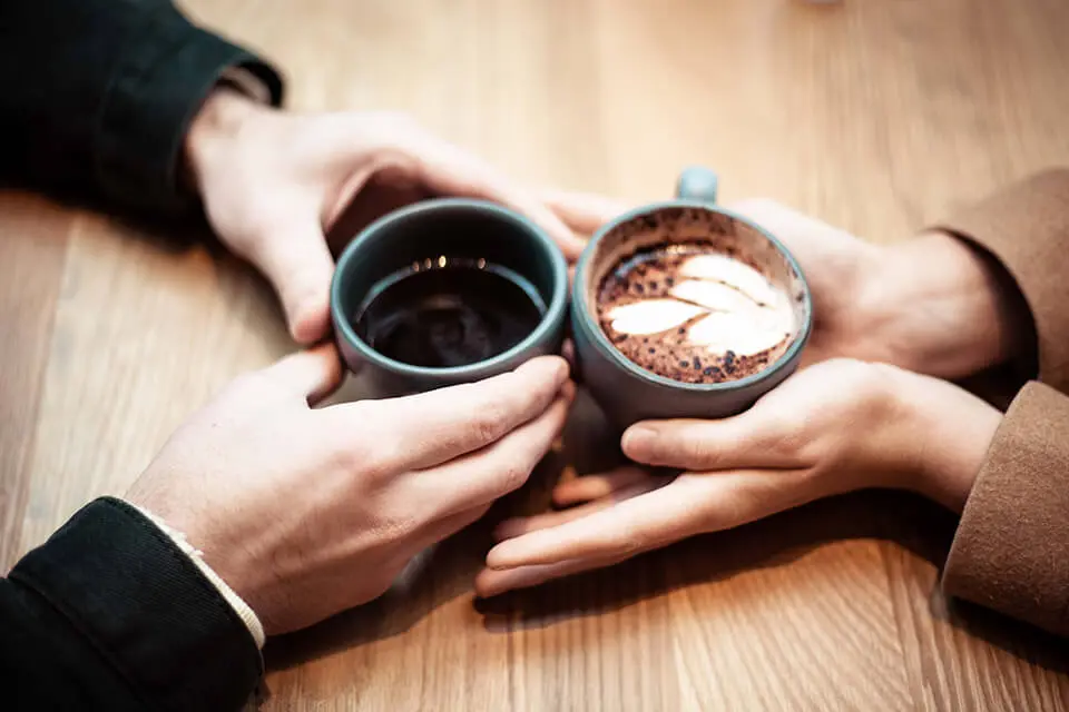 Closeup of two people sitting and having a coffee