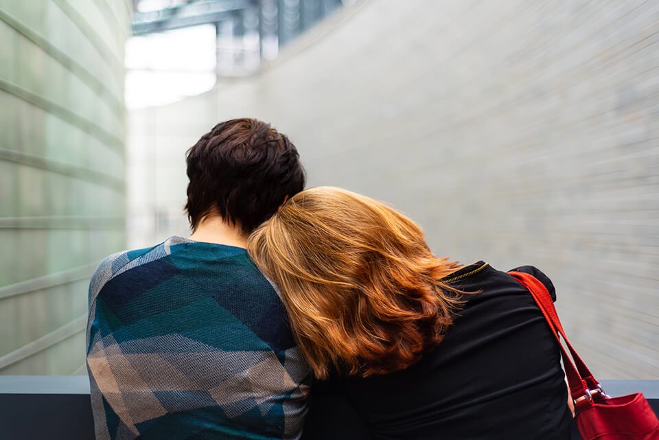 Woman laying her head on the shoulder of a supportive friend