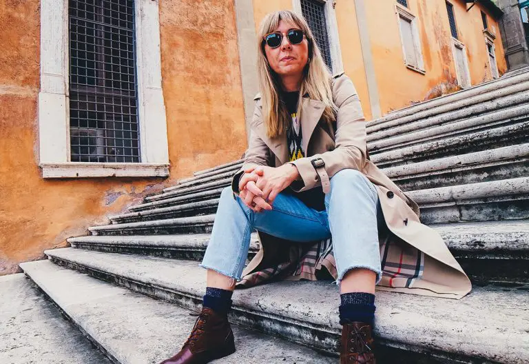 a woman sitting on the steps of a building.