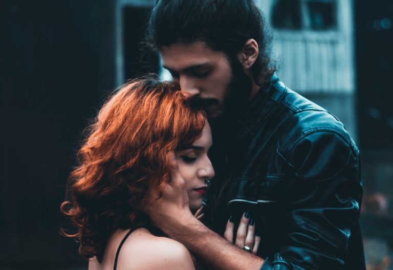 a man standing next to a woman with red hair.