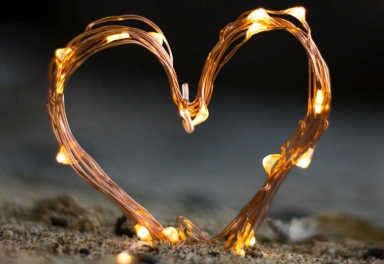 a heart made out of lights sitting on top of a rock.