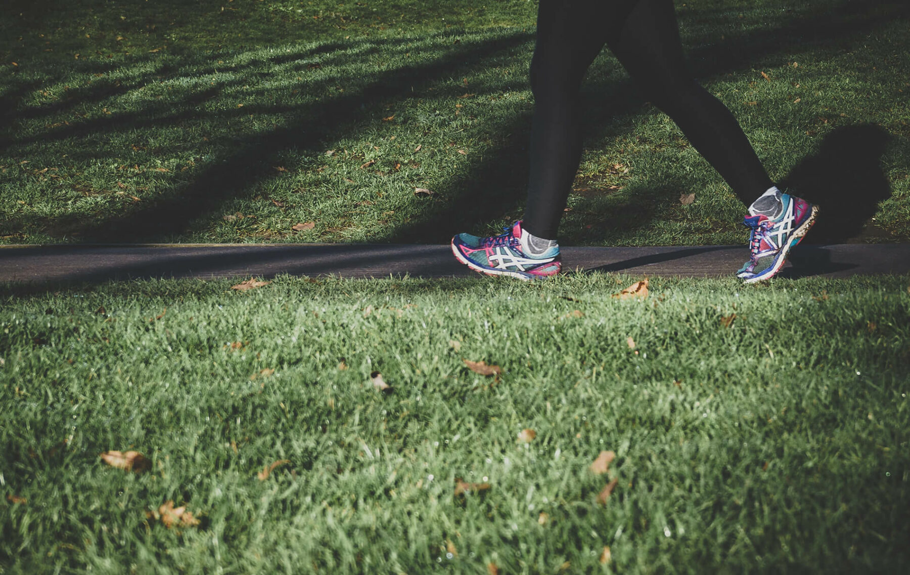 a person walking across a lush green field.