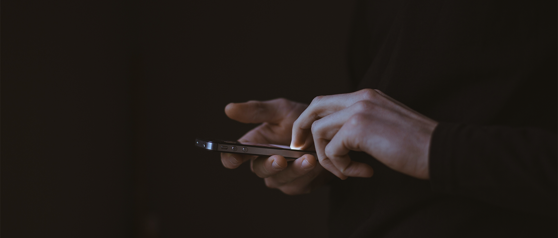 a person holding a cell phone in their hands.