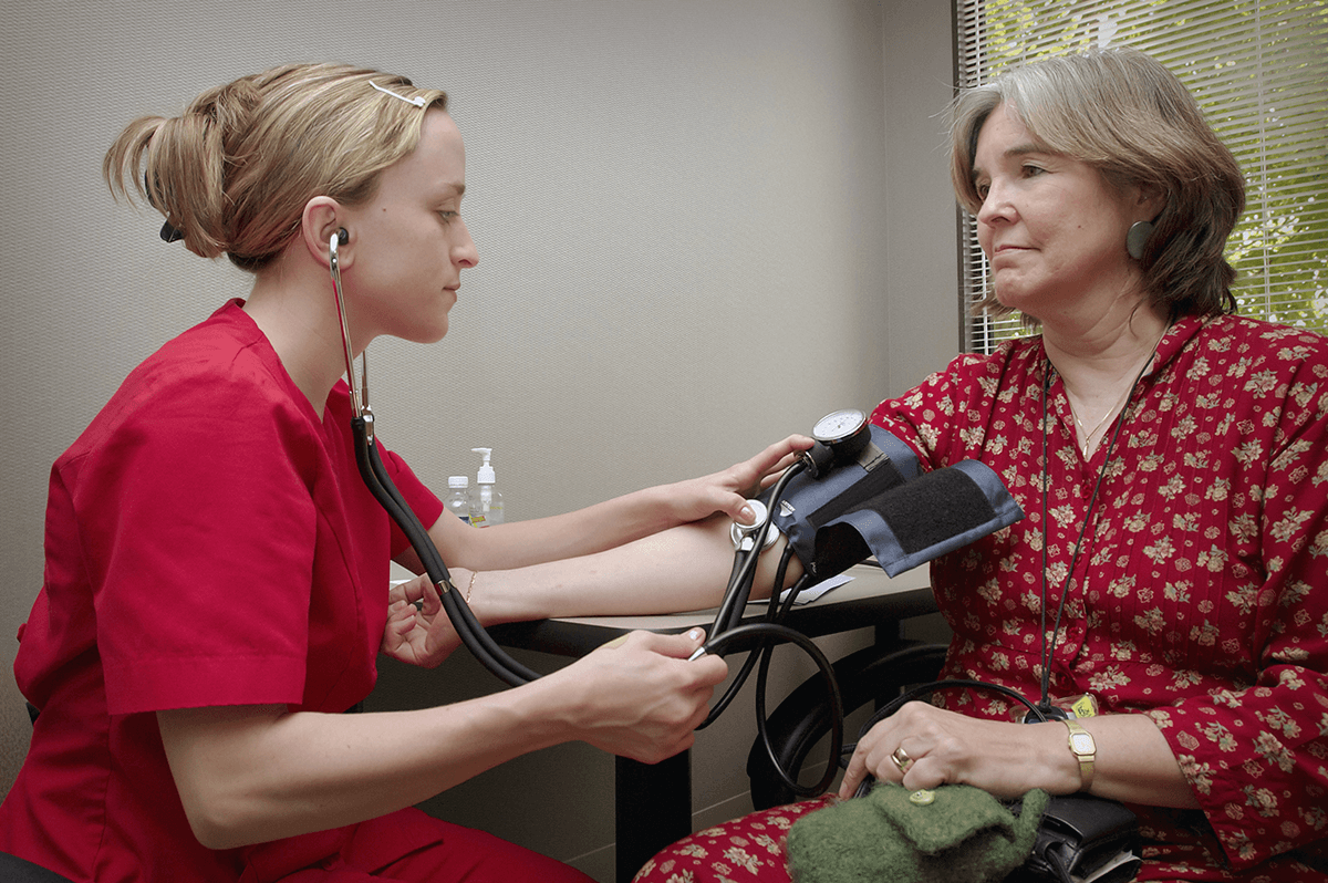 Nurse checking blood pressure of patient