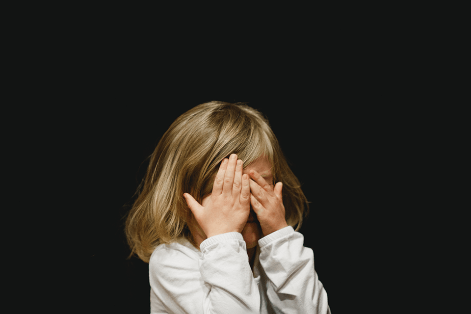 Little girl covering her face