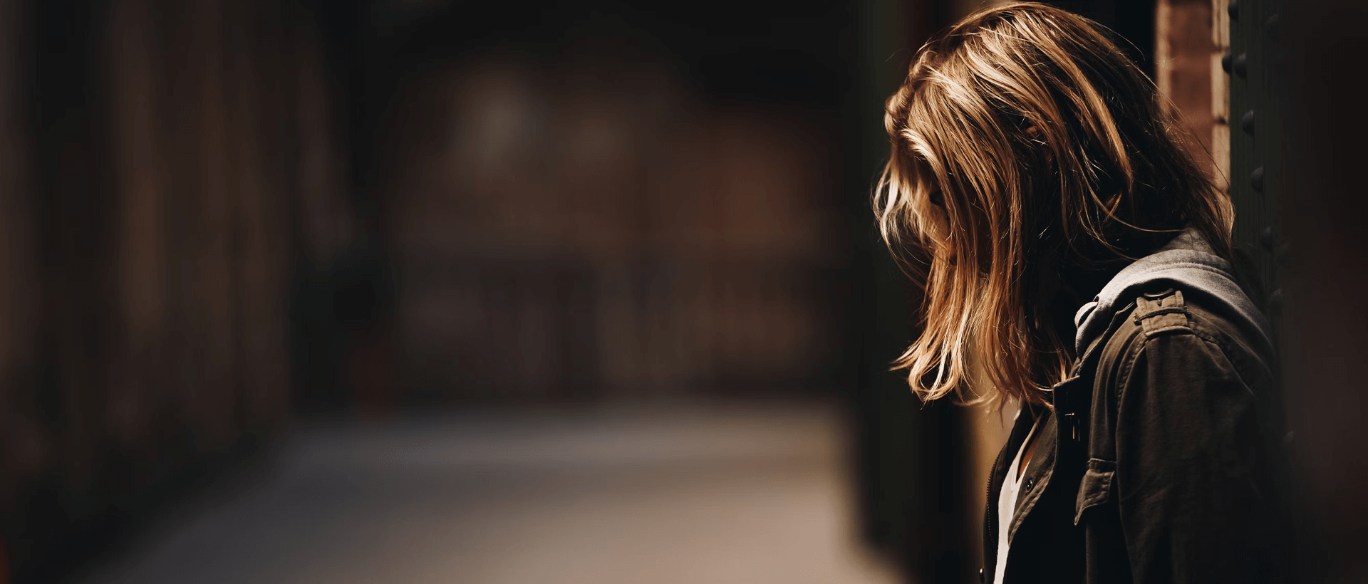 a woman standing in a hallway with her back to the camera.